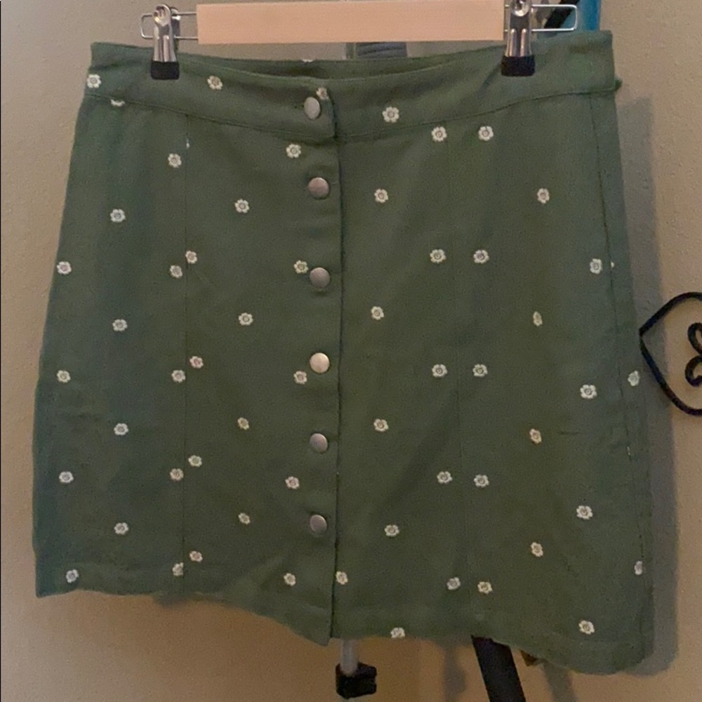 Olive green skirt with white embroidered flowers.